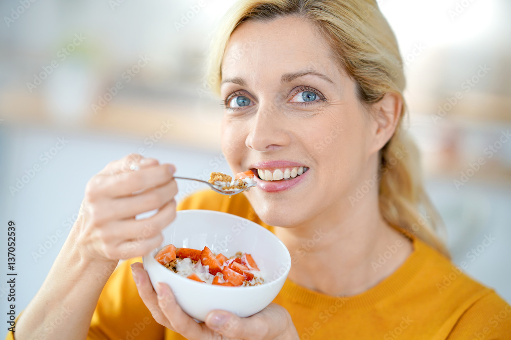 Portrait of blond middle-aged woman eating cereals Portrait of blond middle-aged woman eating cereals