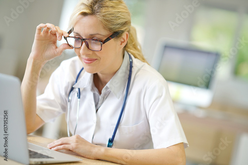 Portrait of doctor working on laptop