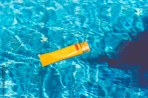 Sunscreen lotion in swimming pool photo