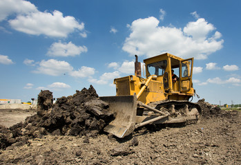 Bulldozer moving earth on sunny day