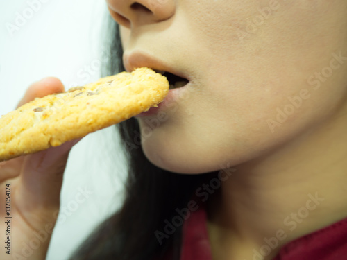 Asian woman eating cookies on white background  close up