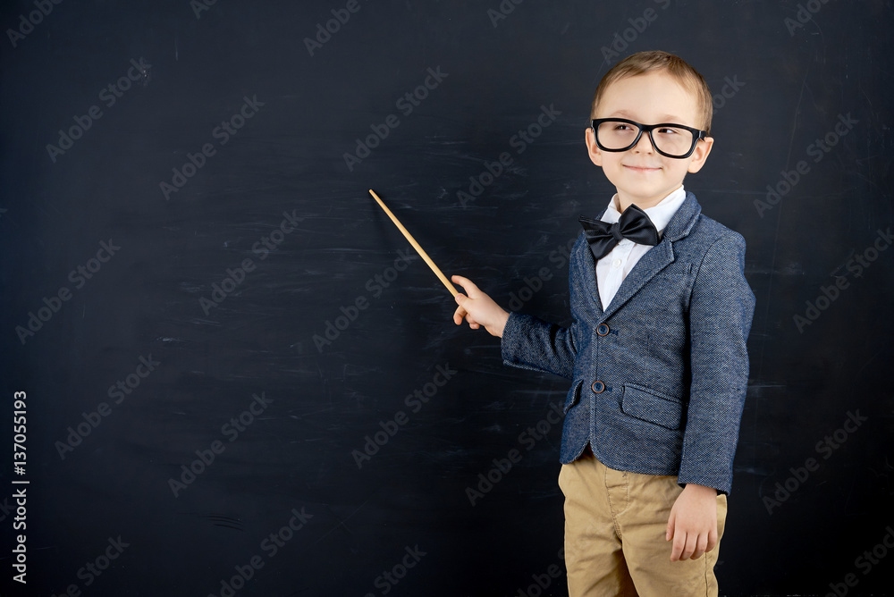 Little boy against blackboard. School concept