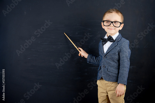 Obraz na płótnie Little boy against blackboard. School concept w salonie