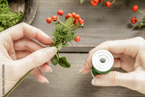 Florist at work: How to make a wreath with red berries (cotoneas photo