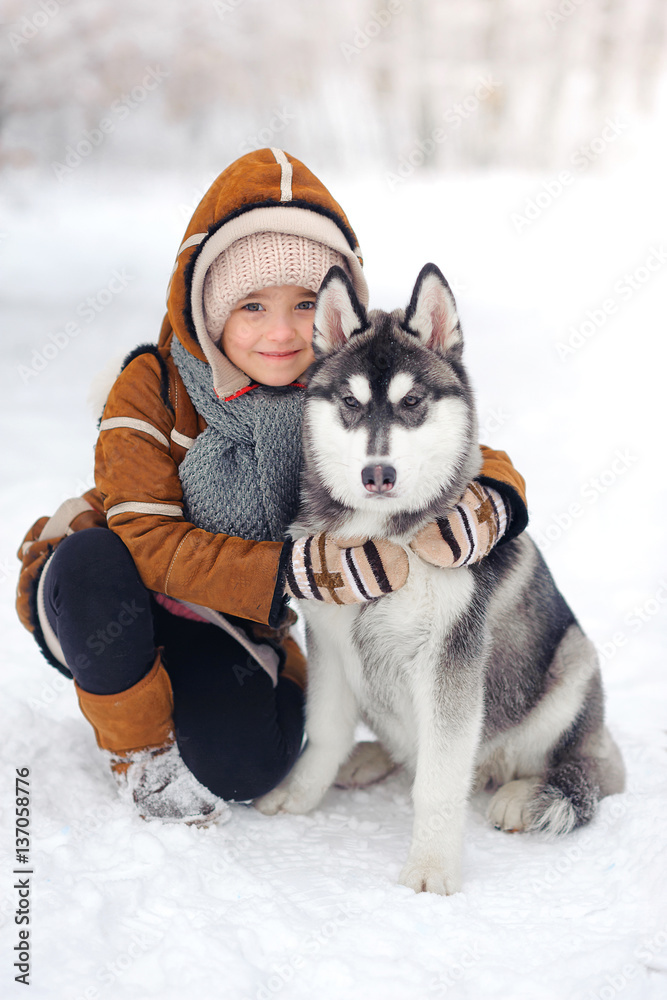happy girl plays with huskies