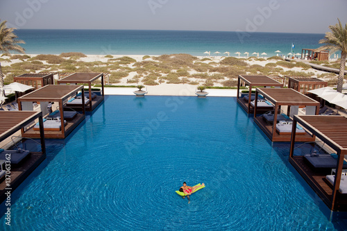 Couple relaxing in swimming pool at Saadiyat Beach Club.