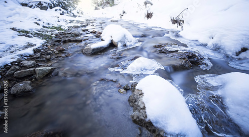 Winter landscape with frozen mountain creek