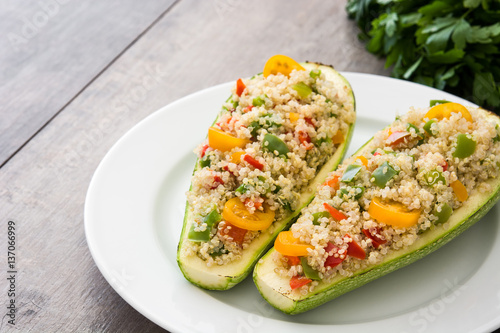 Stuffed zucchini with quinoa and vegetables on wooden background
