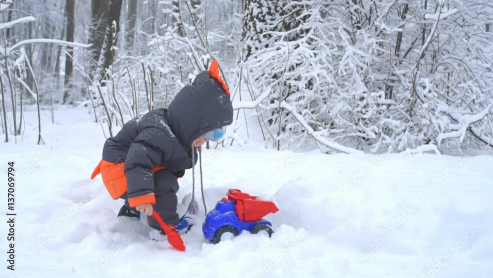 Little boy playing with snow