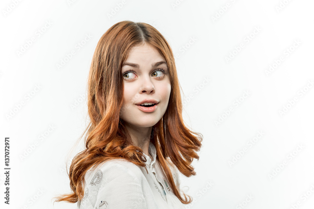 emotional red-haired woman on a light background