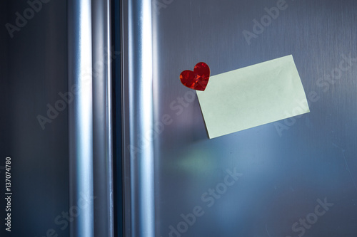 Love note on refrigerator door with heart and evening light