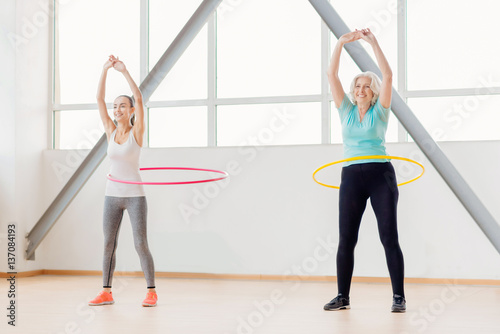 Positive active women rotating hula hoops