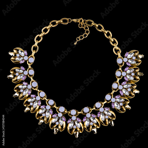 Golden necklace with diamonds on black background