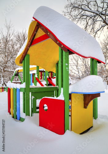 Children's playground covered with snow in winter photo