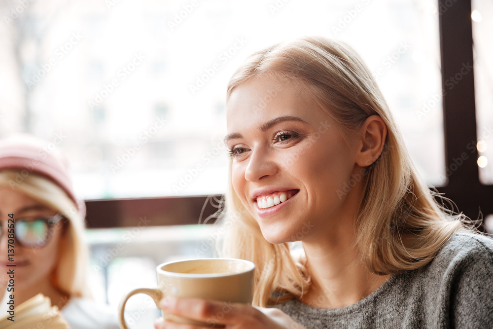 Happy woman sitting in cafe and drinking coffee. Happy woman sitting in cafe and drinking coffee.