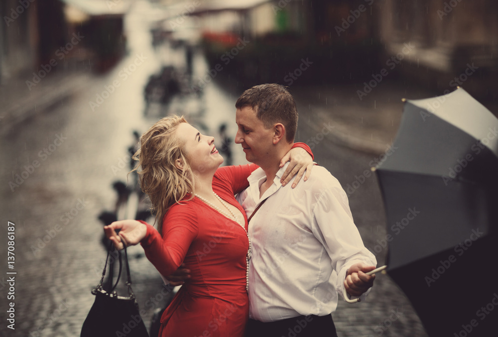 The lovely couple in love embracing on the street - obrazy, fototapety, plakaty 
