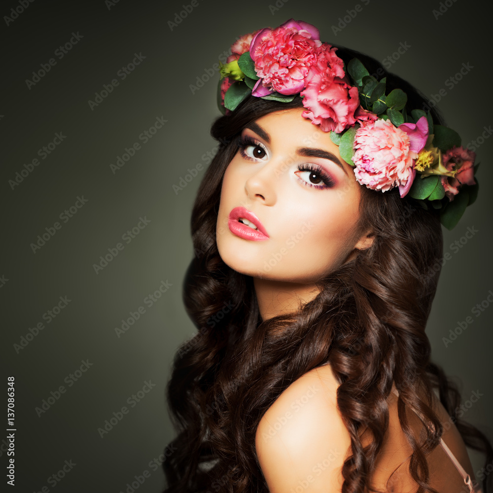 Beautiful Woman Fashion Model with Makeup and Flowers on Night Background. Perfect Curly Hairstyle, Make up and Flowers Wreath