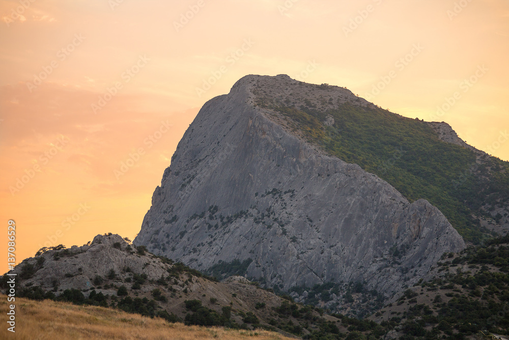 Naklejka premium highest mountain with steep slope at dawn or sunset light pale pink sky