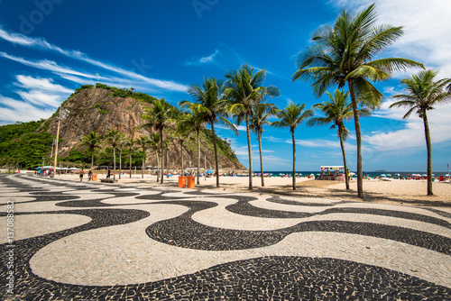 Famous Mosaic of Sidewalk and Palm Trees in Leme and Copacabana Beach in Rio de Janeiro, Brazil photo