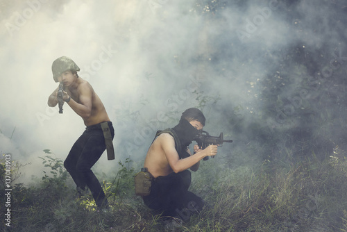 Men aiming with rifle in forest