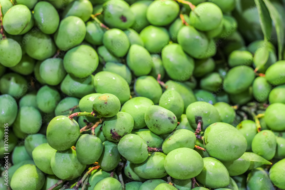 Closeup top view green small mango for sell in the market Closeup top view green small mango for sell in the market