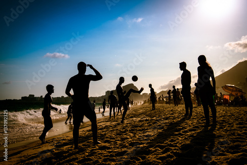 Silhouettes of Brazilians Playing Beach Footbal in Copacabana by Sunset