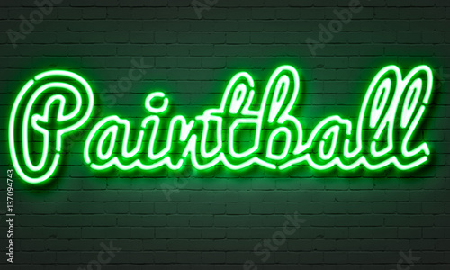 Paintball neon sign on brick wall background.