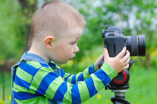 little boy takes off on a photo camera photo