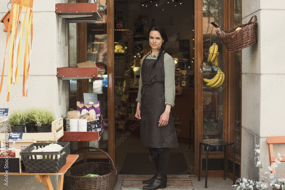Portrait of store owner in front of her business