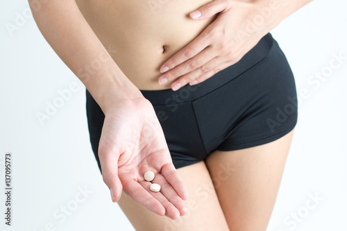 Woman hold medicine and pills with suffering from stomach ache isolated on white background