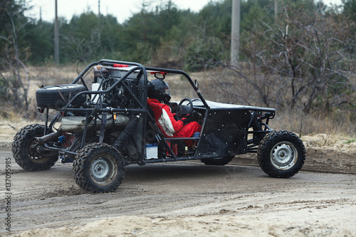 Sports car racing on the track. The driver behind the wheel of a buggy with a second driver photo