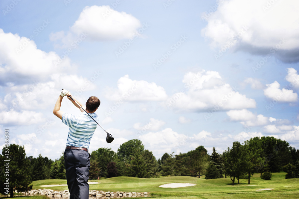 Golfer watches the ball after drive Golfer watches the ball after drive