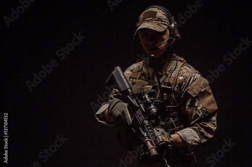 Portrait soldier or private military contractor holding sniper rifle. war, army, weapon, technology and people concept. Image on a black background.