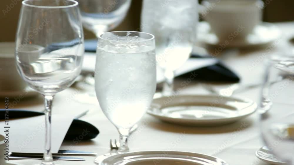 Close up pan of a set table in a banquet hall.