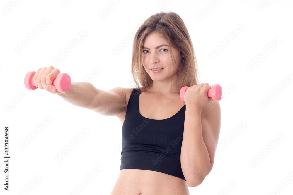 sports girl smiling and holding out one hand with a small pink dumbbell sports girl smiling and holding out one hand with a small pink dumbbell