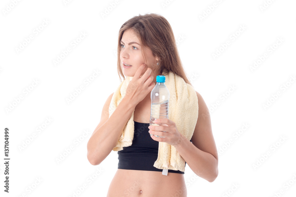 Slim girl with towel on his shoulders holding a bottle isolated white background Slim girl with towel on his shoulders holding a bottle isolated white background