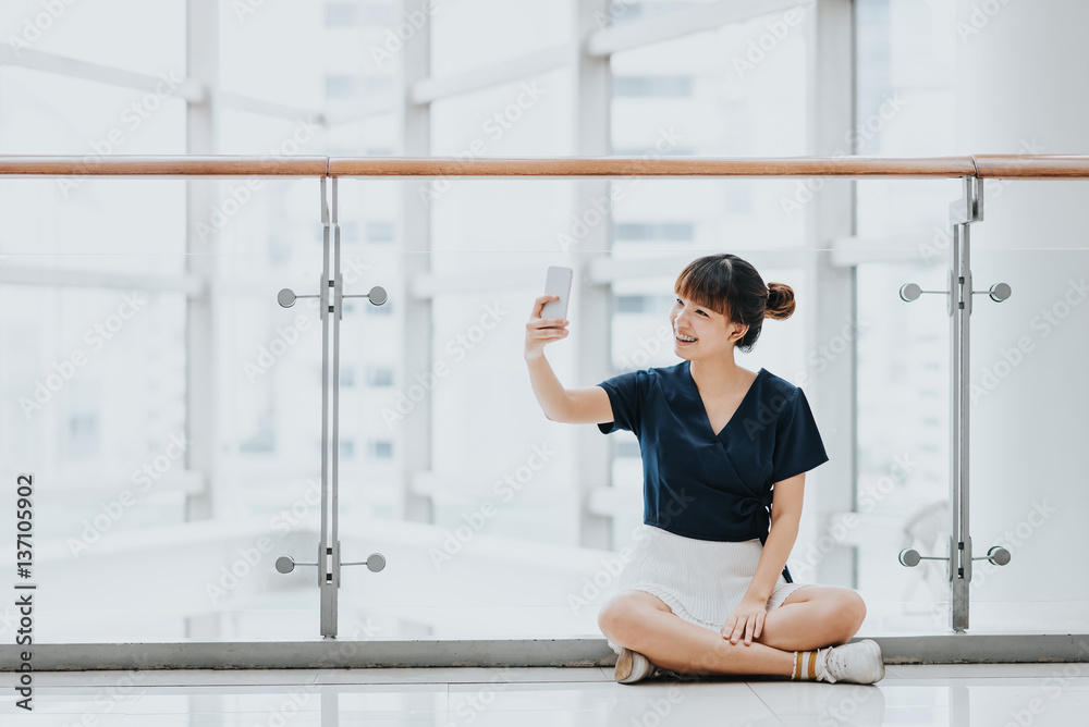 Young beautiful happy Asian girls best laugh and smile while having fun with smart phone mobile indoor.