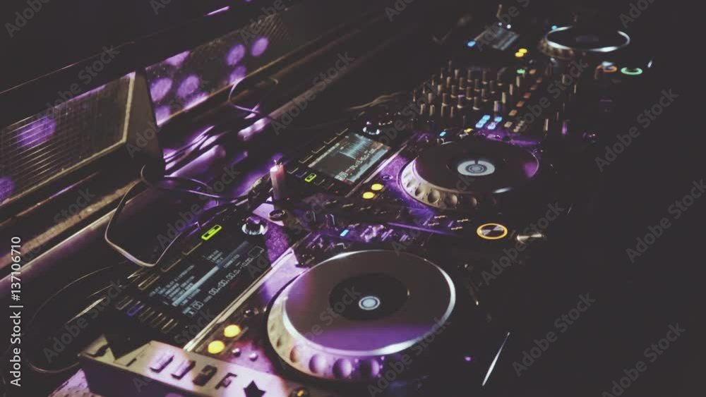 behind dj decks and mixer in night club, staic angle shot