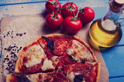 rustic italian pizza with mozzarella, cheese and basil leaves photo