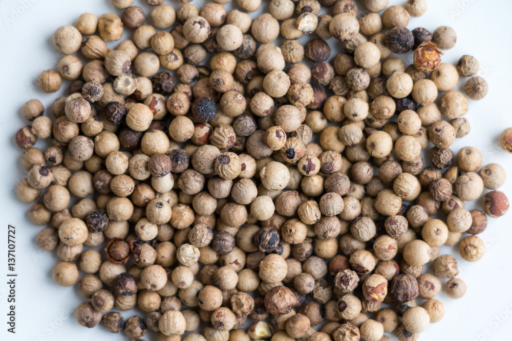 White peppercorns on white table. Top view. Selective focus. White peppercorns on white table. Top view. Selective focus.