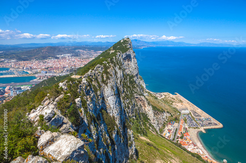 Aerial view of top of Gibraltar Rock, in Upper Rock Natural Reserve: on the left Gibraltar town and bay, La Linea town in Spain at the far end, Mediterranean Sea on the right. United Kingdom, Europe.
