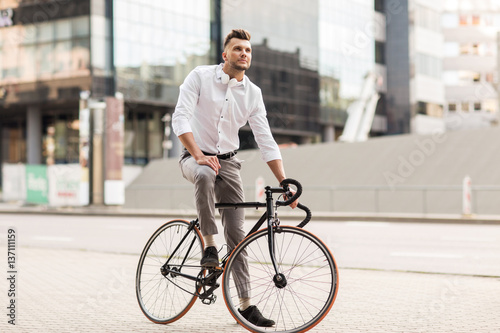 man with bicycle and headphones on city street