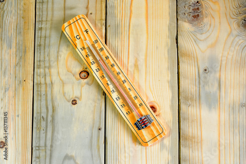 Thermometer on a wooden background