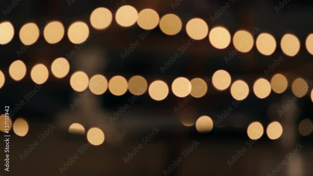 Stringed lights out of focus, hanging outdoors