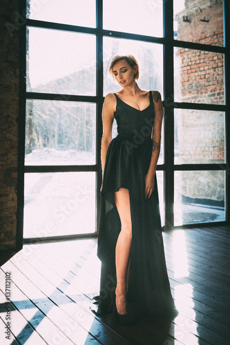 Free Download beautiful blonde in a little black dress near a large window - GFXLoad
