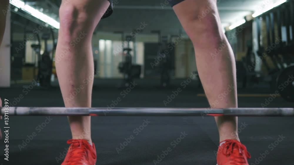 Fit young man lifting barbells working out in a gym, slow motion Fit young man lifting barbells working out in a gym, slow motion