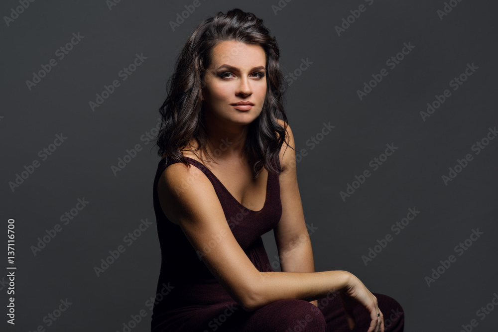 Portrait of young woman on grey background. Brunette with brown eyes. Portrait of young woman on grey background. Brunette with brown eyes.