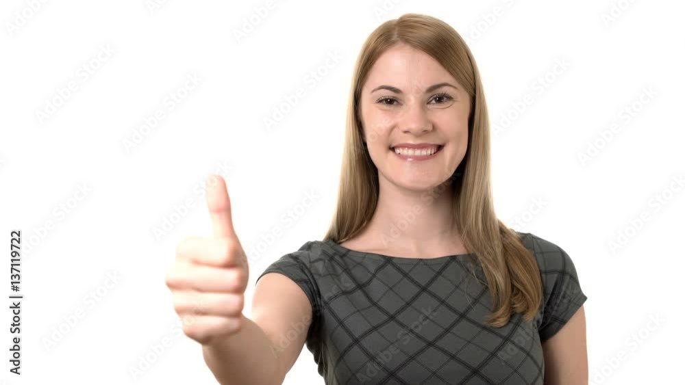 Beautiful serious young businesswoman in grey dress showing thumb-up. Isolated white background Beautiful serious young businesswoman in grey dress showing thumb-up. Isolated white background