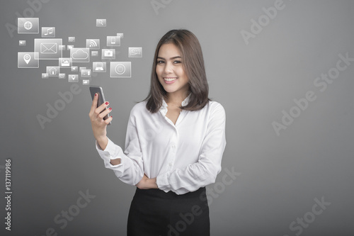 Beautiful business Woman using smartphone on grey background