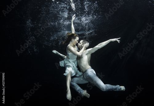 Fototapeta Naklejka Na Ścianę i Meble -  Young couple dancing underwater